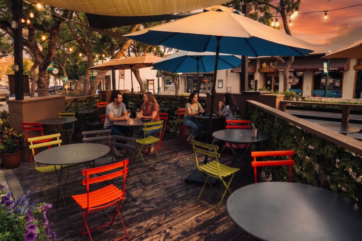 The Blue Fish sidewalk patio at sunset, umbrellas and string lights on Honolulu Avenue in Montrose